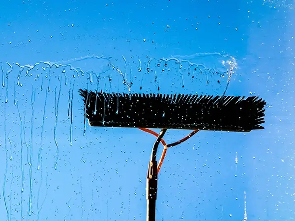 professional window cleaning brush removing water from exterior glass in Kansas City metro area